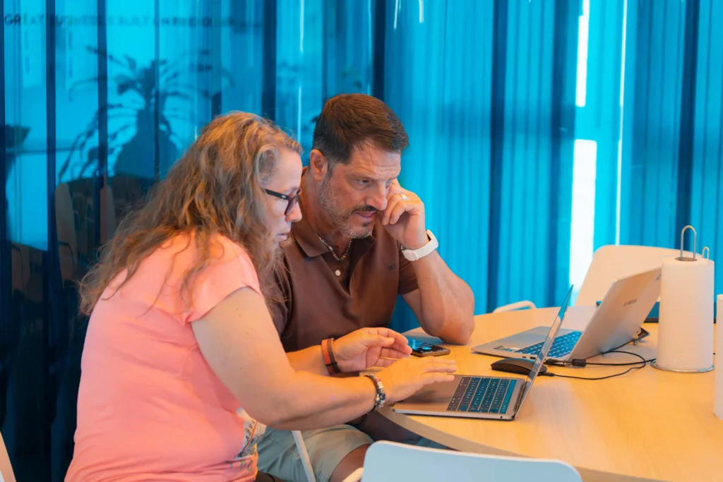 Eine Mitarbeiterin und ein Mitarbeiter von WATA Factory arbeiten konzentriert an ihren Laptops während der Kubernetes-Schulung.