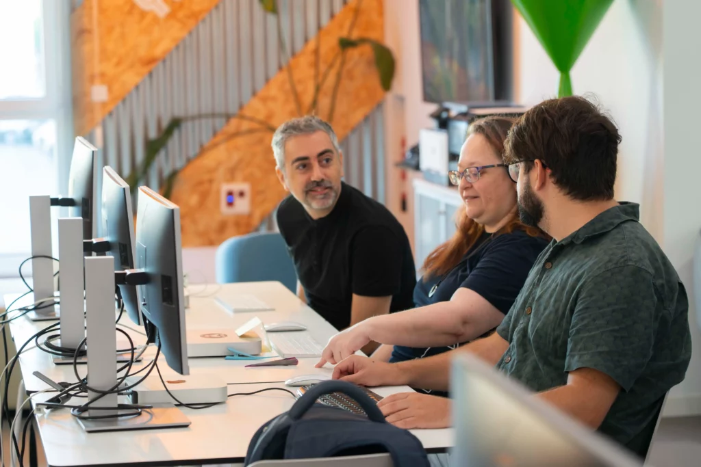 Empleados de WATA Factory debatiendo juntos durante el taller de DevOps y Kubernetes.