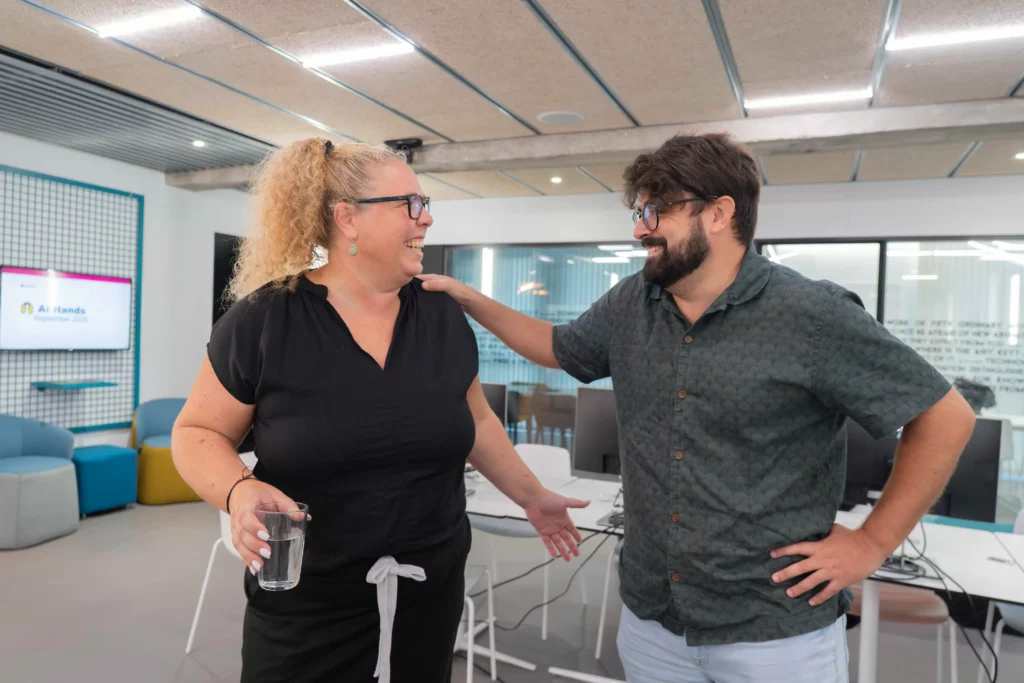 Dos compañeros de WATA Factory se despiden con alegría en las oficinas tras el All Hands.