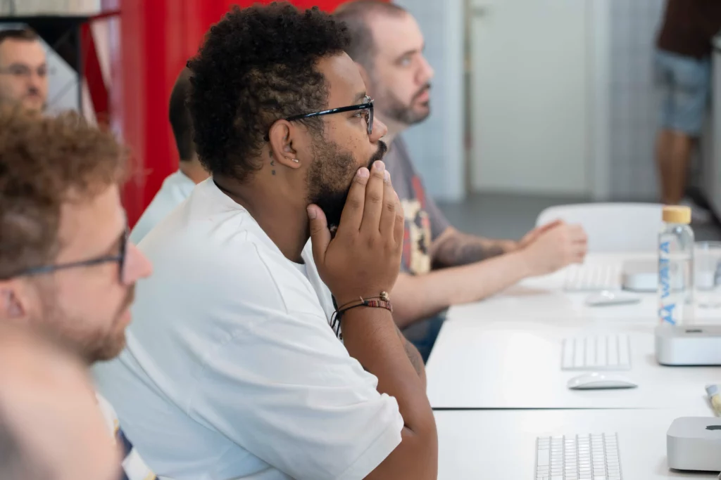 Empleados de WATA Factory siguiendo con portátiles la práctica guiada por Pedro G. sobre Kubernetes.