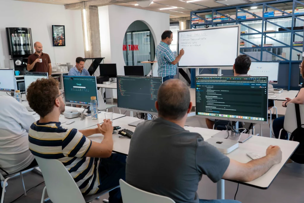 Pedro G. erklärt den praktischen Kubernetes-Workshop, während die Mitarbeiter aufmerksam zuhören.
