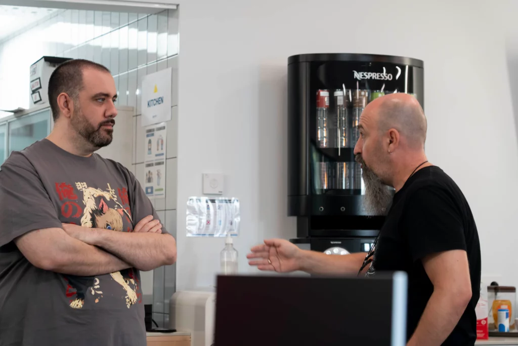Dos compañeros de WATA Factory conversan animadamente al cierre del All Hands de Kubernetes.