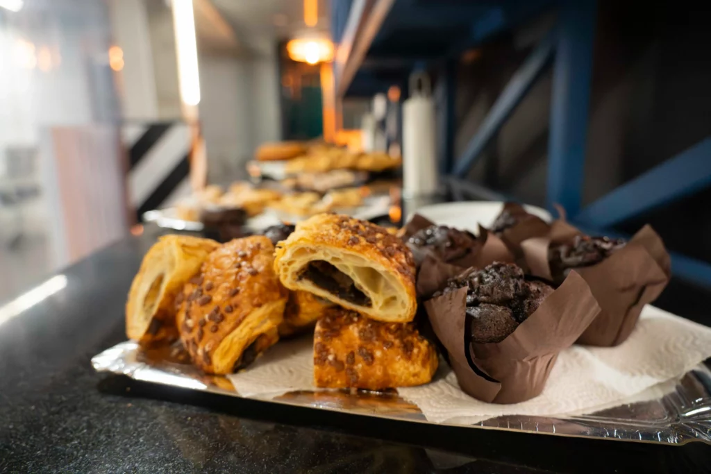 Buffet de desayuno en WATA Factory con bollería variada antes de la formación en Kubernetes.