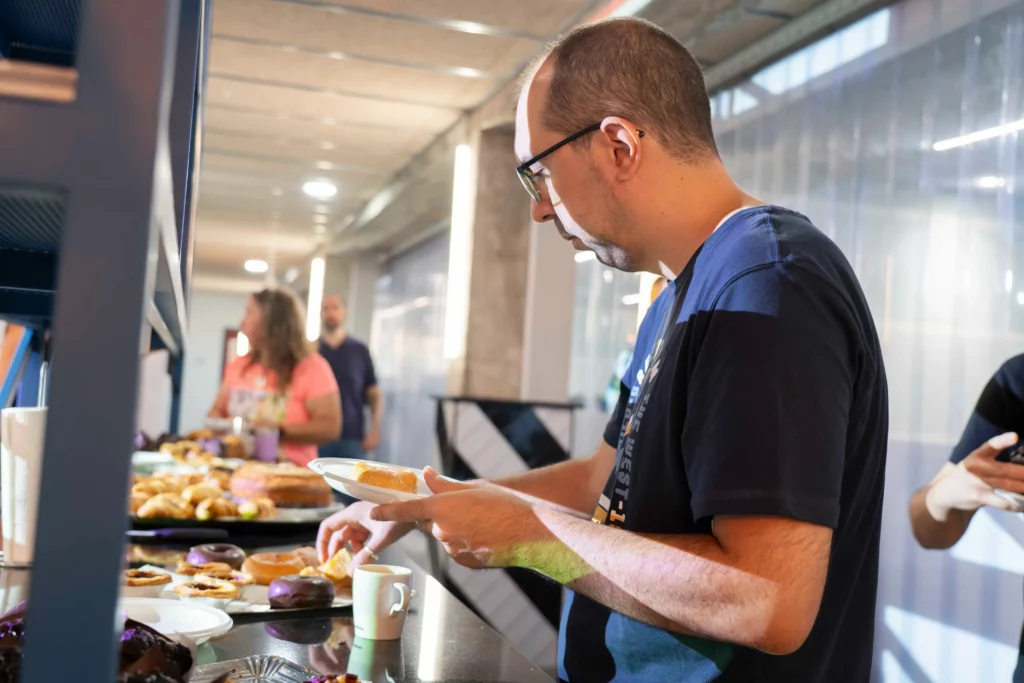 WATA Factory employee serving pastries at the breakfast before the Kubernetes workshop.