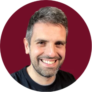 Professional portrait of Carlos Azaustre, JavaScript expert and author, smiling against WATA Factory corporate red background